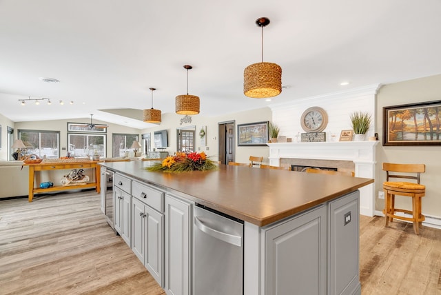 kitchen featuring pendant lighting, a center island, wine cooler, vaulted ceiling, and light wood-type flooring