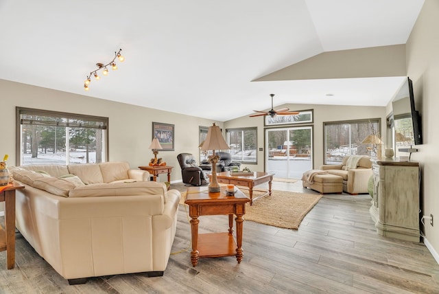 living room featuring light wood-type flooring, vaulted ceiling, plenty of natural light, and ceiling fan