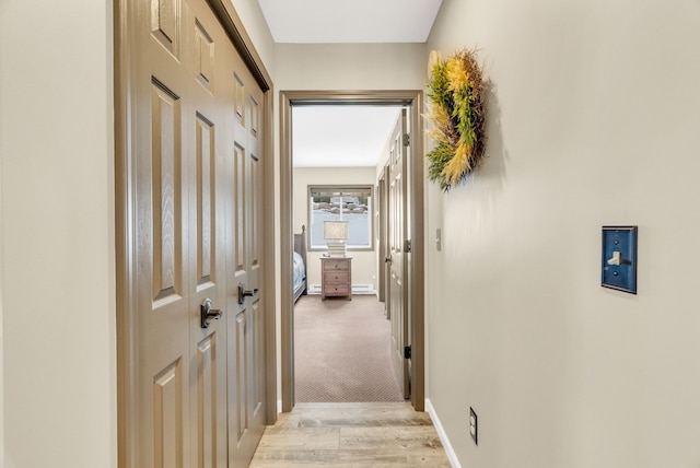 corridor with a baseboard radiator and light wood-type flooring