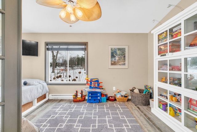 bedroom featuring lofted ceiling, ceiling fan, wood-type flooring, and a baseboard radiator