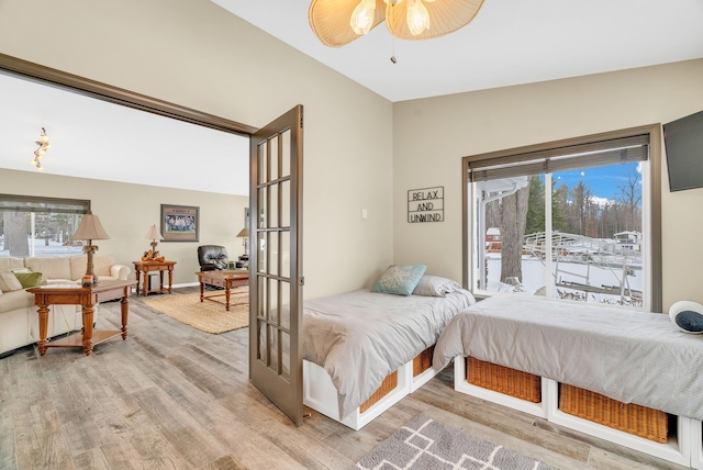 bedroom with hardwood / wood-style flooring, ceiling fan, and french doors