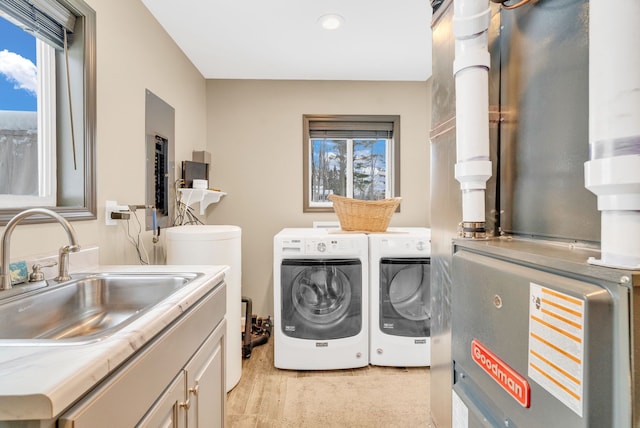 clothes washing area featuring sink, cabinets, washing machine and dryer, heating unit, and light colored carpet