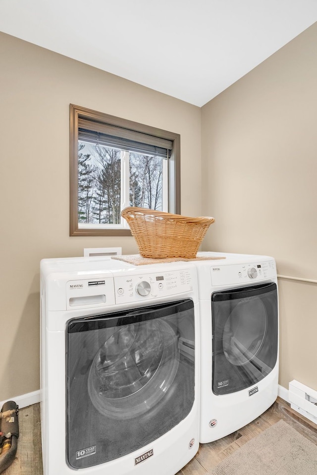 1571 Loebrich Dr, Gladwin, MI 48624 - laundry room featuring washer and clothes dryer, light wood-style flooring, and baseboard heating