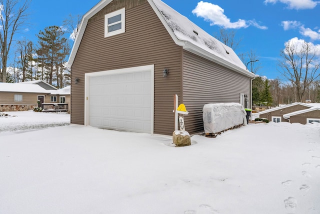 snow covered property with a garage