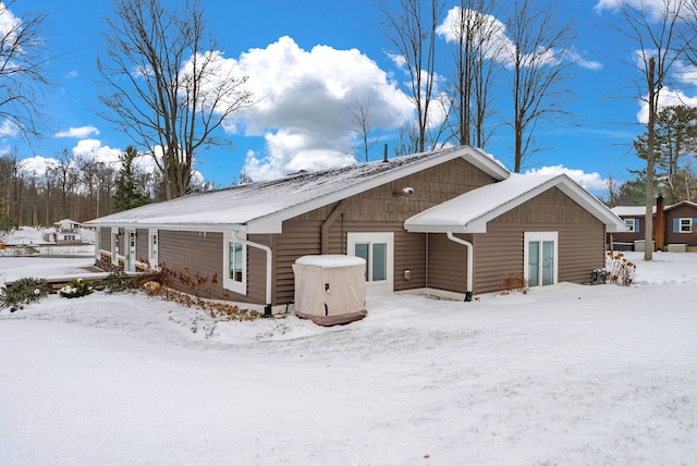 view of snow covered back of property