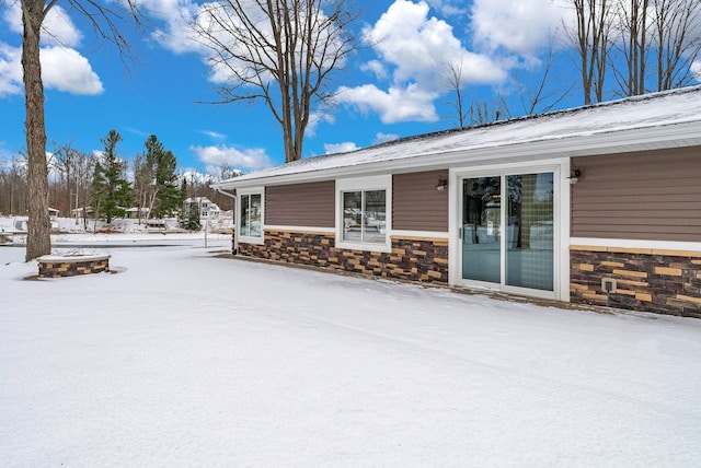 1571 Loebrich Dr, Gladwin, MI 48624 - snow covered property with stone siding