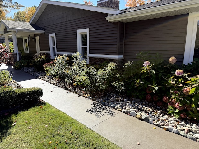 1571 Loebrich Dr, Gladwin, MI 48624 - view of property exterior featuring a chimney and stone siding