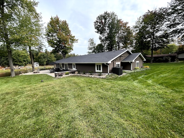 1571 Loebrich Dr, Gladwin, MI 48624 - back of property with a patio area, a lawn, and view of wooded area