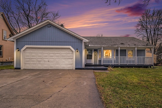 single story home featuring a yard, covered porch, and a garage