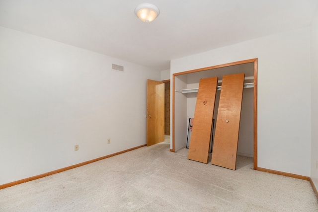 unfurnished bedroom featuring light carpet and a closet