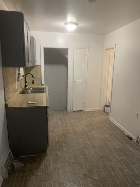 kitchen featuring backsplash, dark hardwood / wood-style flooring, and sink