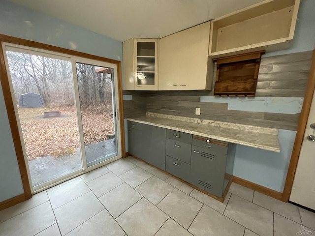 kitchen featuring backsplash, gray cabinets, and light tile patterned flooring