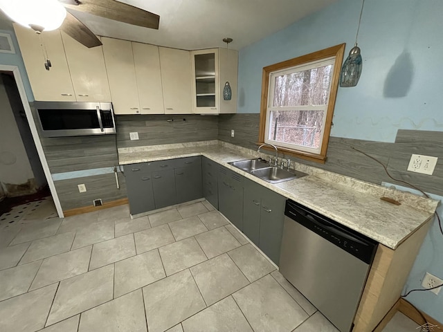 kitchen featuring appliances with stainless steel finishes, gray cabinetry, sink, decorative light fixtures, and white cabinets