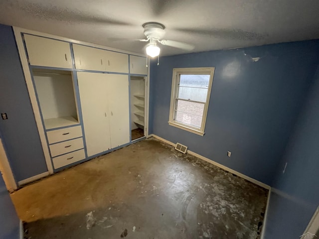 unfurnished bedroom featuring ceiling fan, concrete flooring, a textured ceiling, and a closet