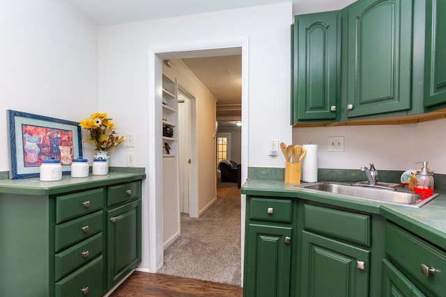 kitchen featuring dark carpet, green cabinets, and sink