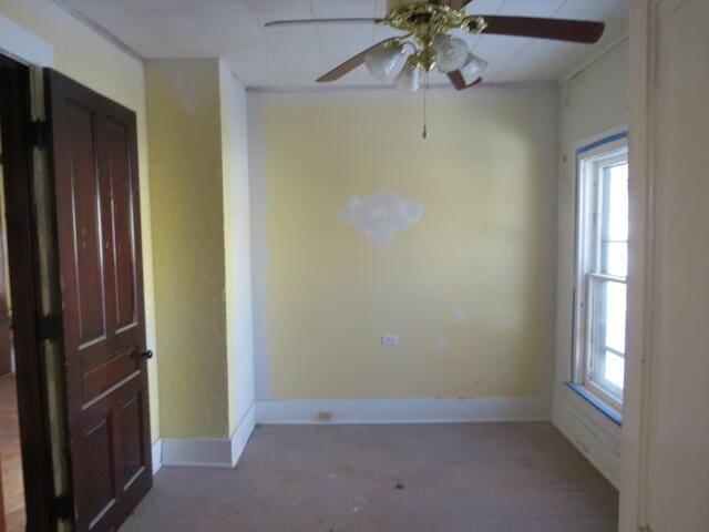 unfurnished room featuring ceiling fan and plenty of natural light