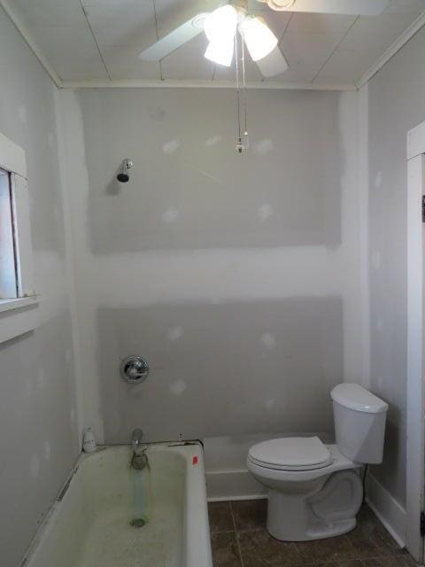 bathroom with a washtub, tile patterned flooring, toilet, and ceiling fan