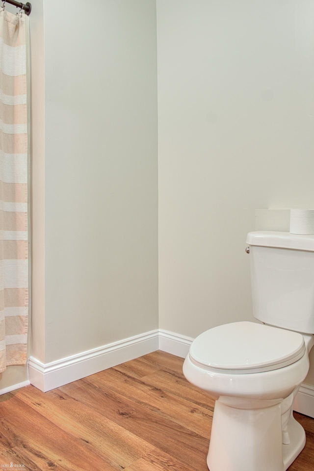 bathroom with hardwood / wood-style floors and toilet