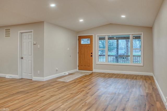 entrance foyer with light hardwood / wood-style floors and vaulted ceiling