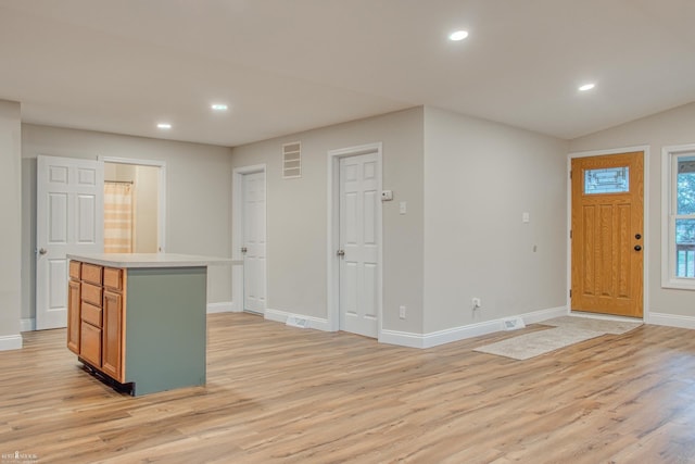 kitchen featuring light hardwood / wood-style flooring, a kitchen island, and lofted ceiling