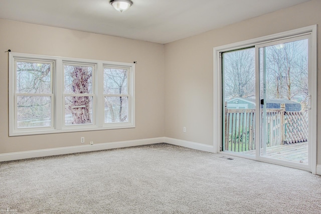 carpeted empty room with a healthy amount of sunlight