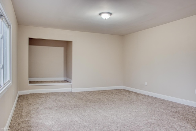 carpeted spare room featuring a wealth of natural light