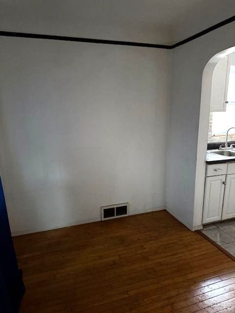 unfurnished dining area featuring sink and wood-type flooring