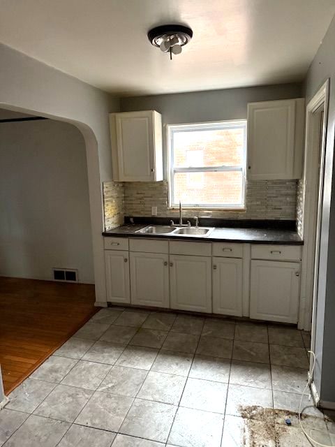 22482 W Mcnichols Rd, Detroit, MI 48219 - kitchen featuring tasteful backsplash, dark countertops, and light tile patterned floors