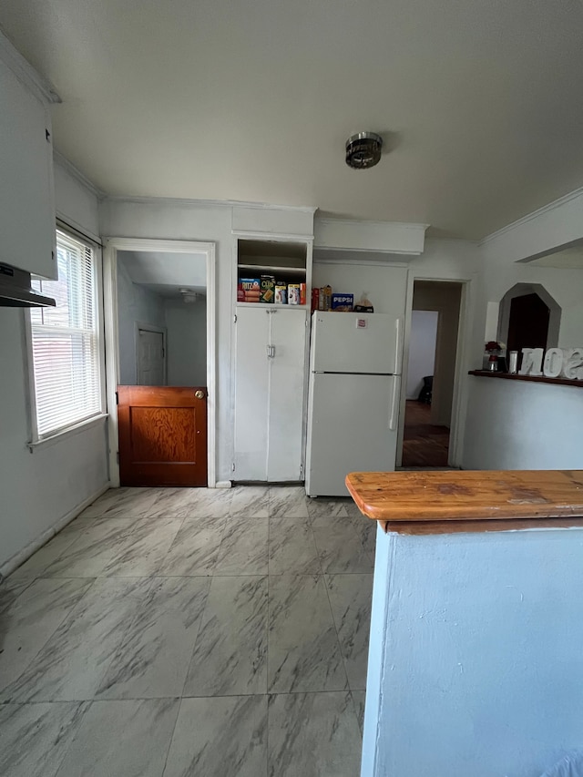 kitchen with white fridge and white cabinetry