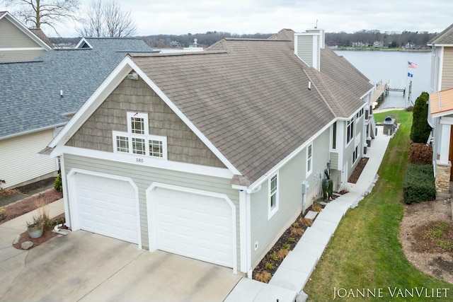 585 Crescent Dr, Holland, MI 49423 - view of property exterior featuring concrete driveway, roof with shingles, a chimney, and an attached garage