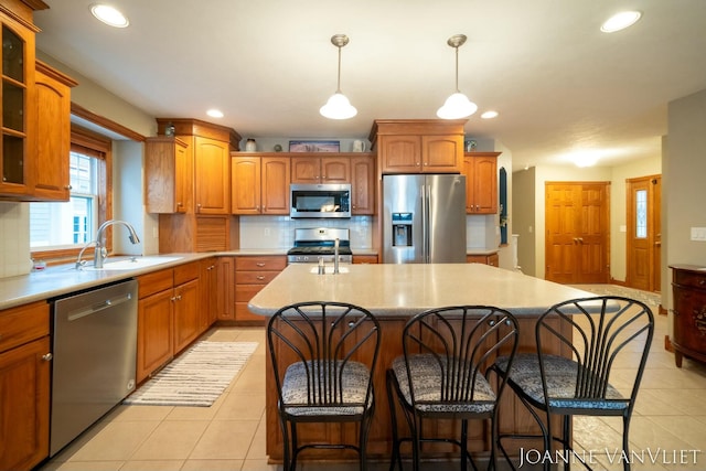 585 Crescent Dr, Holland, MI 49423 - kitchen featuring light tile patterned floors, an island with sink, a sink, stainless steel appliances, and decorative backsplash