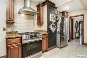 kitchen with wall chimney exhaust hood, light tile patterned flooring, backsplash, and appliances with stainless steel finishes