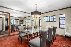 carpeted dining area with a notable chandelier and crown molding