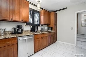 kitchen featuring light stone countertops, sink, light tile patterned flooring, and stainless steel dishwasher