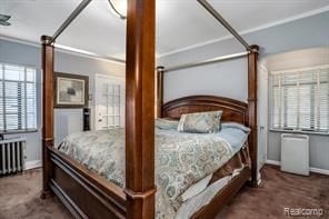 bedroom featuring dark carpet, radiator heating unit, and crown molding