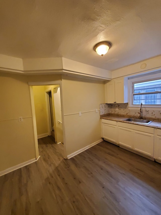 kitchen featuring tasteful backsplash, a textured ceiling, sink, dark hardwood / wood-style floors, and white cabinetry