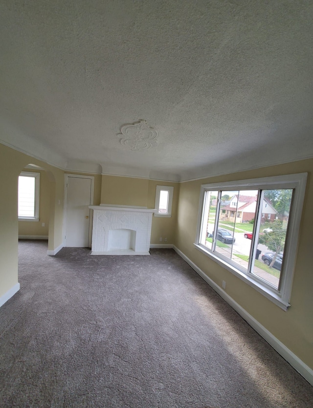 unfurnished living room with carpet flooring and a textured ceiling