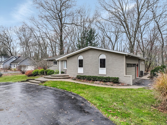 view of front of home featuring a garage, central AC, and a front yard