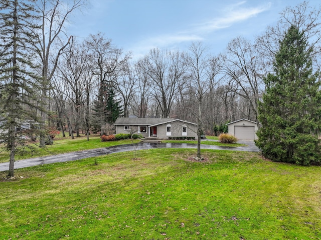 view of front of house with an outbuilding, a garage, and a front lawn