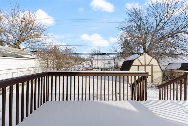 snow covered deck featuring an outdoor structure