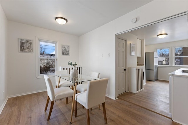 dining area with light hardwood / wood-style flooring and a wealth of natural light