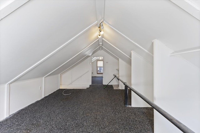 bonus room featuring dark colored carpet and vaulted ceiling