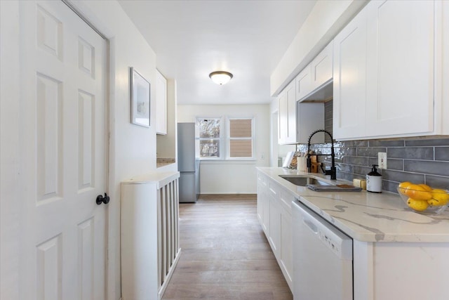 kitchen with stainless steel refrigerator, dishwasher, sink, light hardwood / wood-style floors, and white cabinets