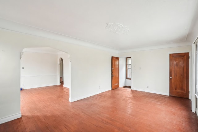 empty room with crown molding and wood-type flooring