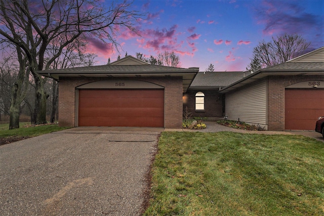 ranch-style home featuring a yard and a garage