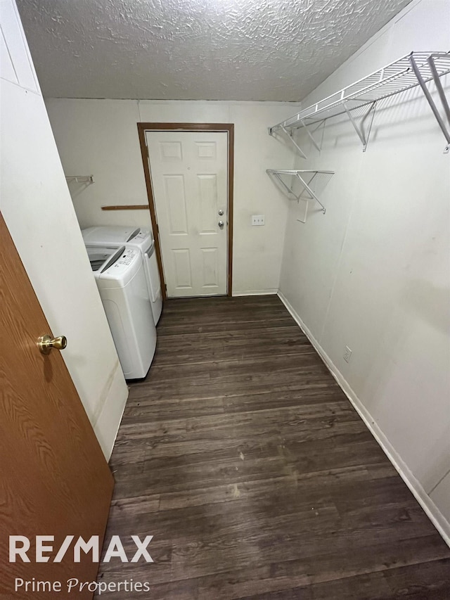 laundry room with washing machine and dryer, dark hardwood / wood-style floors, and a textured ceiling