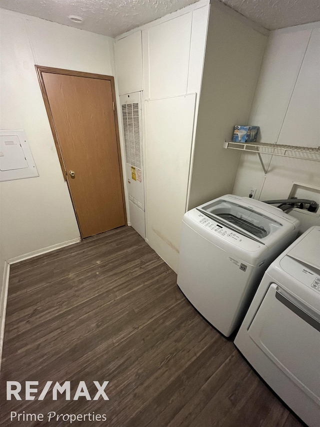 clothes washing area with dark hardwood / wood-style floors, washer and clothes dryer, and a textured ceiling