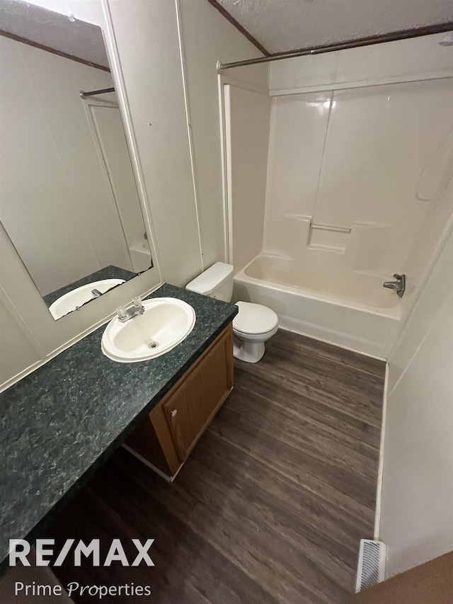 full bathroom with vanity, hardwood / wood-style floors, toilet, and shower / bath combination