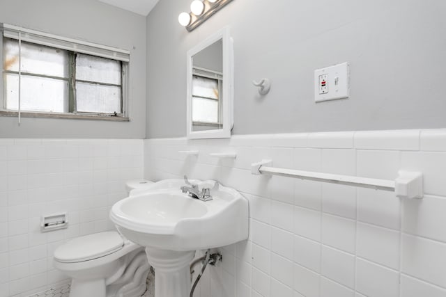 bathroom featuring tile patterned floors, tile walls, and toilet