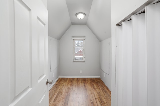 additional living space with vaulted ceiling and light hardwood / wood-style flooring